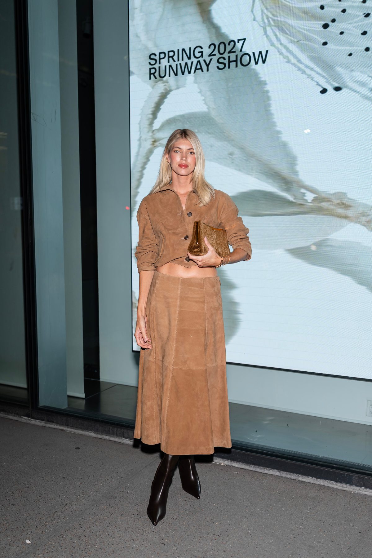 Brown suede cropped jacket, matching midi skirt, brown pointed-toe boots, and a textured clutch.