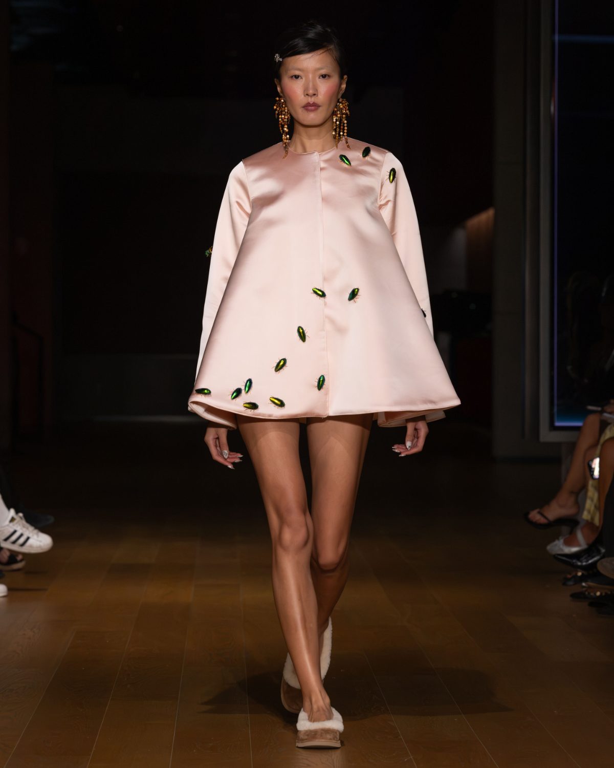 Light pink babydoll dress with emerald green beetle embellishments and beaded earrings.