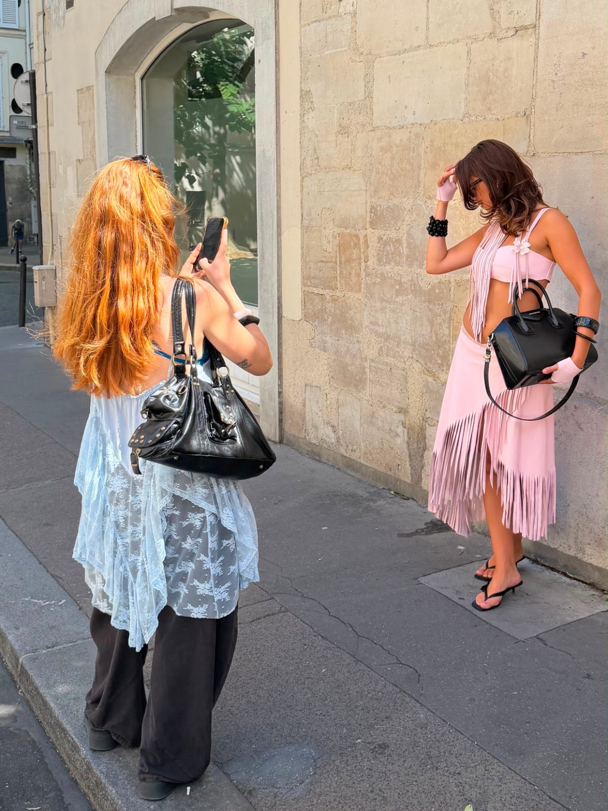 Pink fringe crop top and skirt set, black heels and bag, photographed on a street.