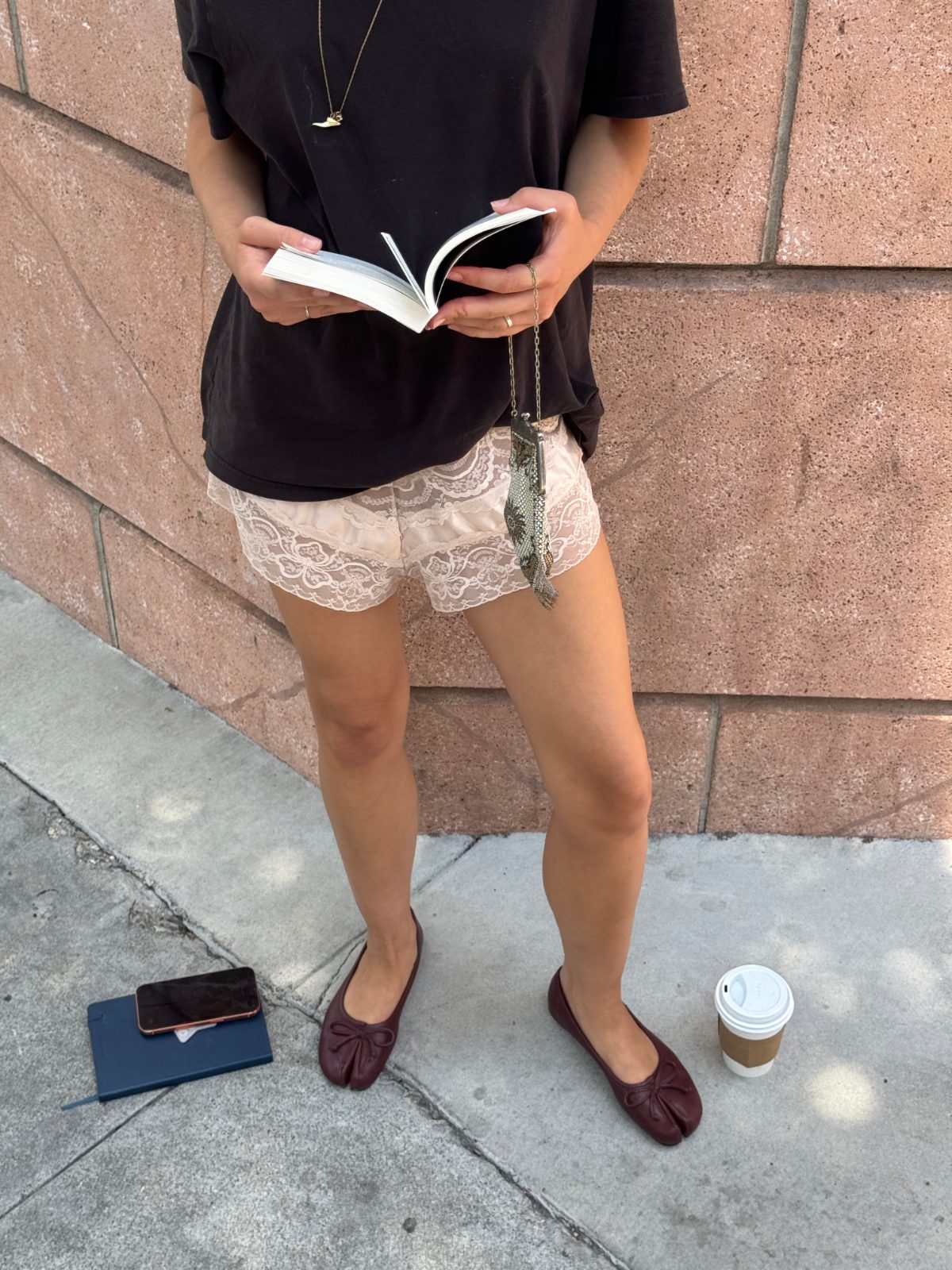 Black t-shirt, lace shorts, brown ballet flats, and gold accessories.