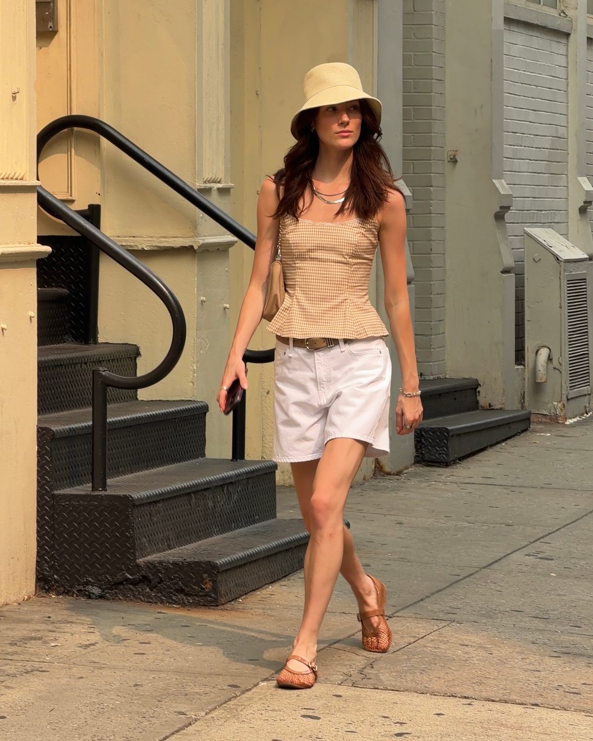 Beige gingham peplum top, white shorts, straw hat, and mesh ballet flats.