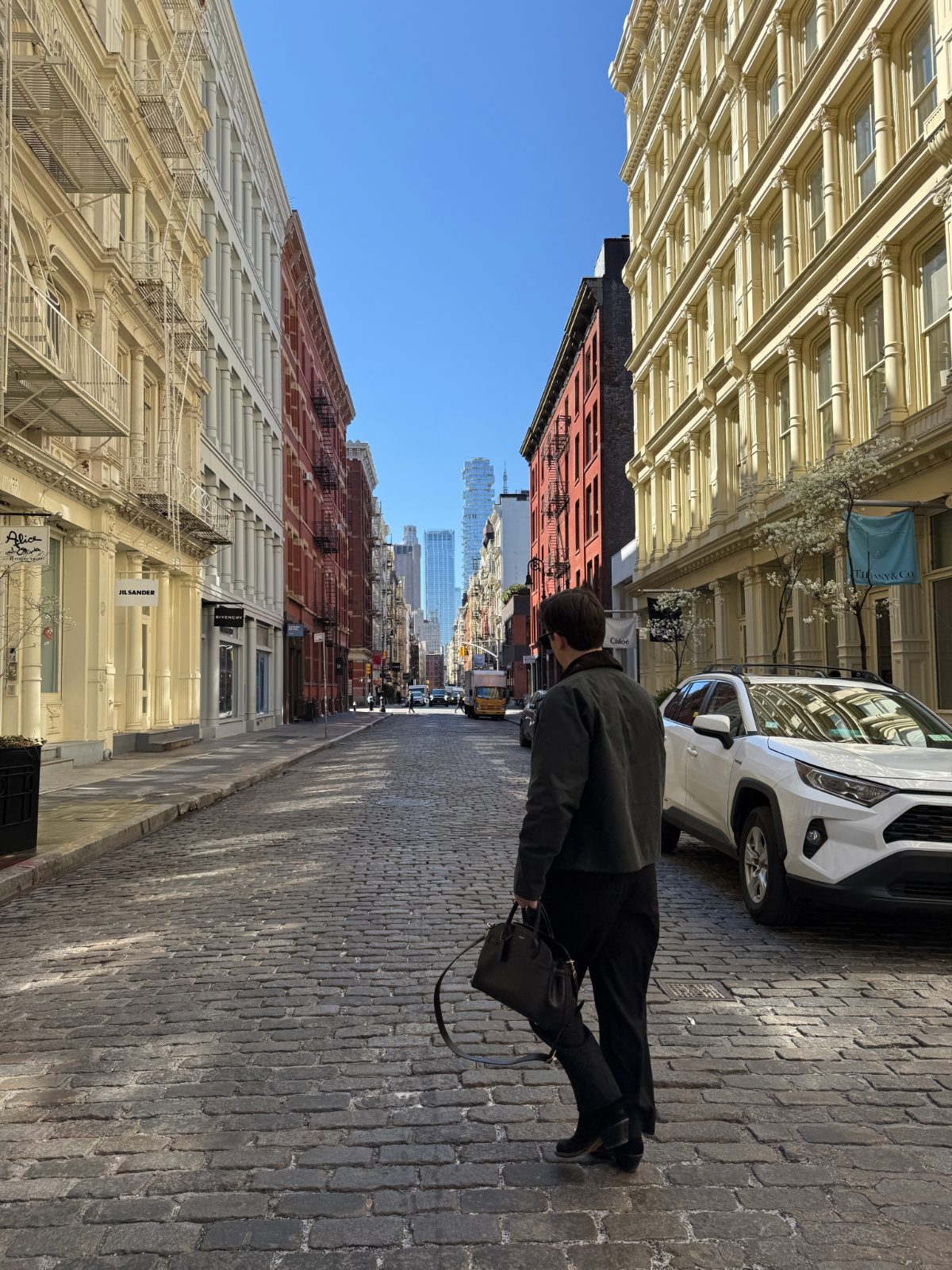  black leather top-handle satchel, pairing it with a waxed dark jacket, a white tee, and black trousers
