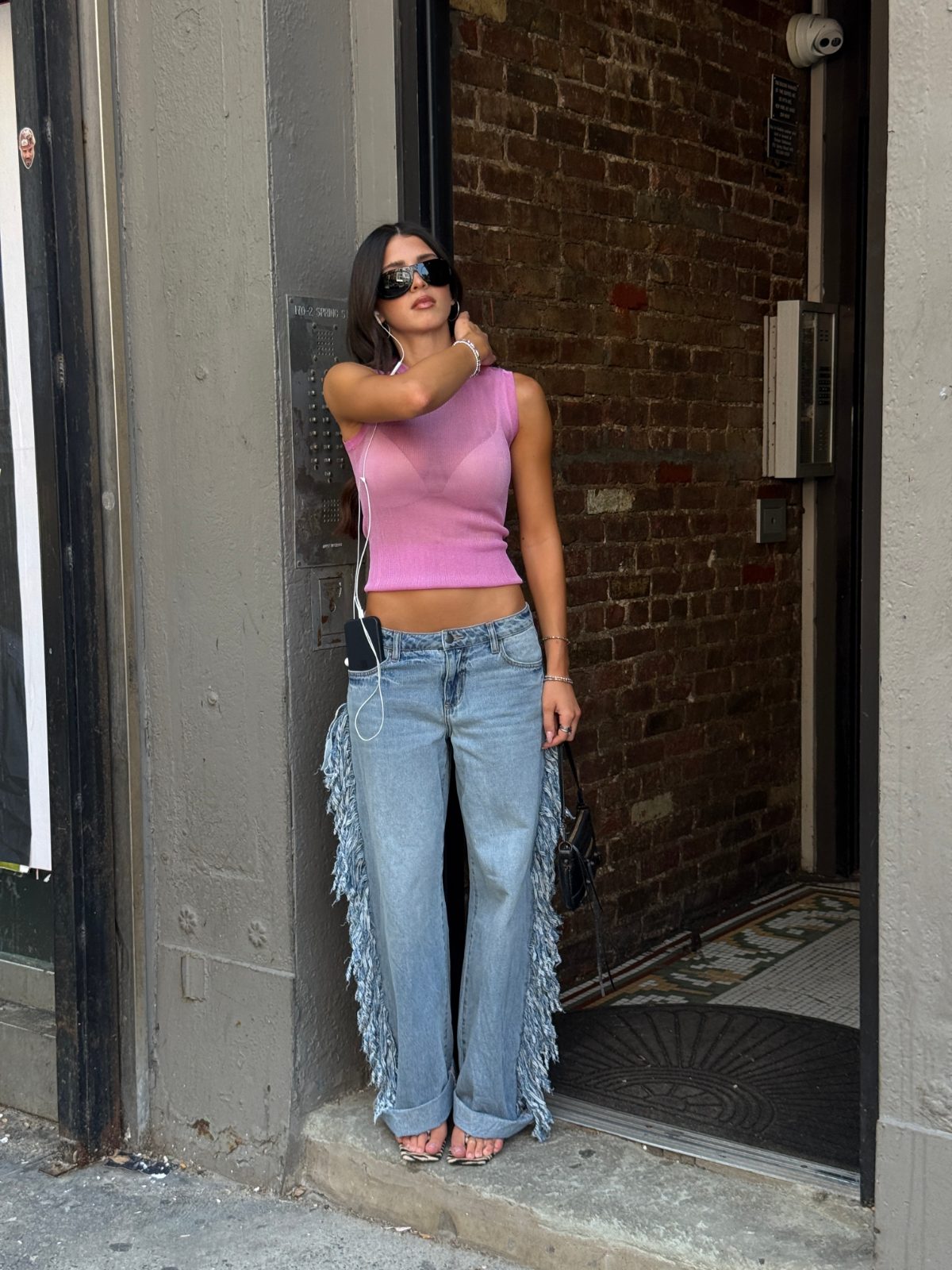Pink sheer knit tank top, fringe light wash jeans, and zebra print sandals.