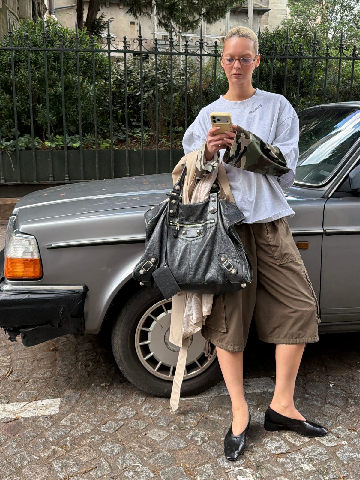 Gray oversized sweatshirt, brown cargo shorts, black flats, and large black tote bag.