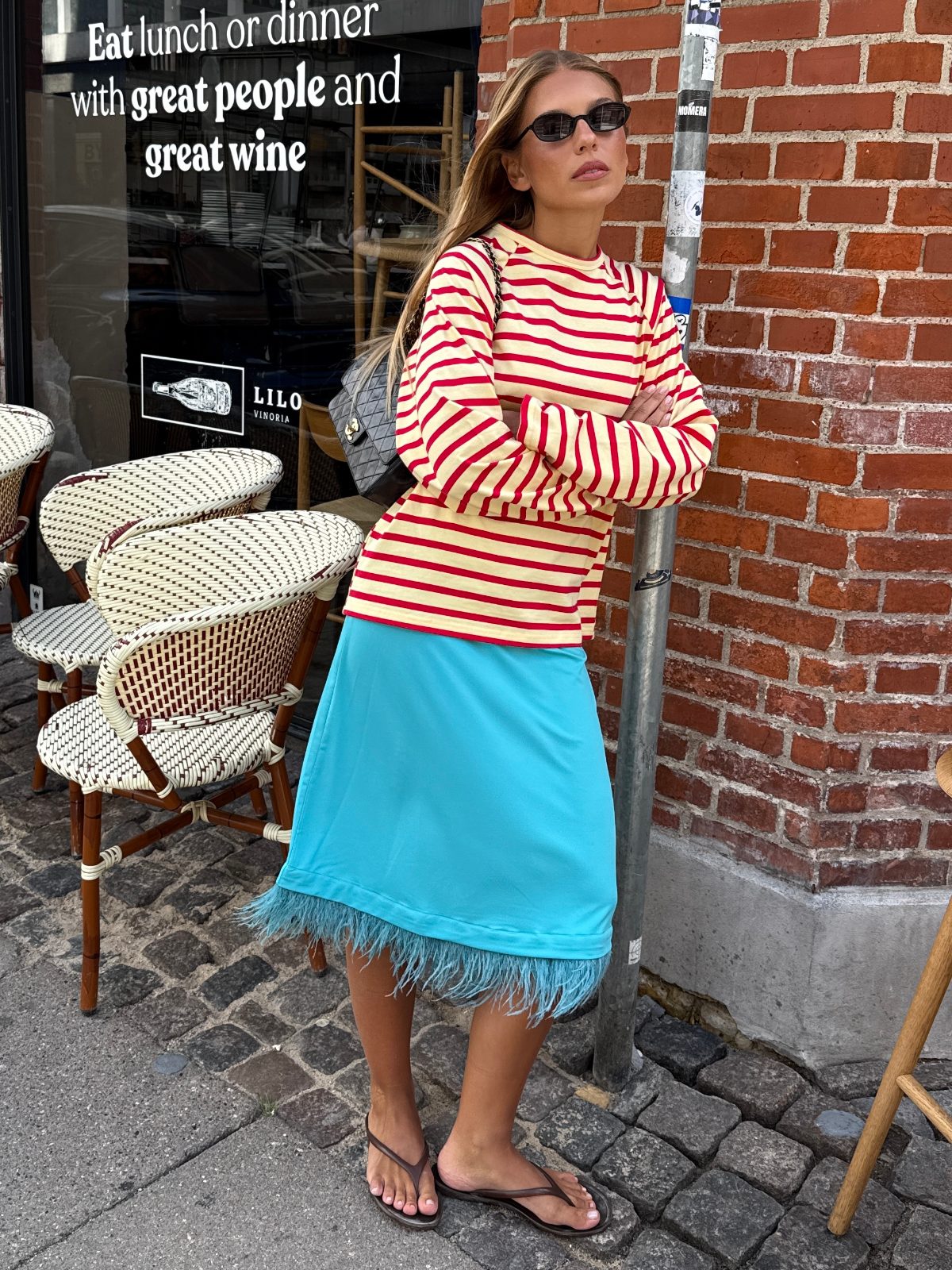 Yellow and red striped long-sleeve top with a blue skirt featuring a feathered hem.