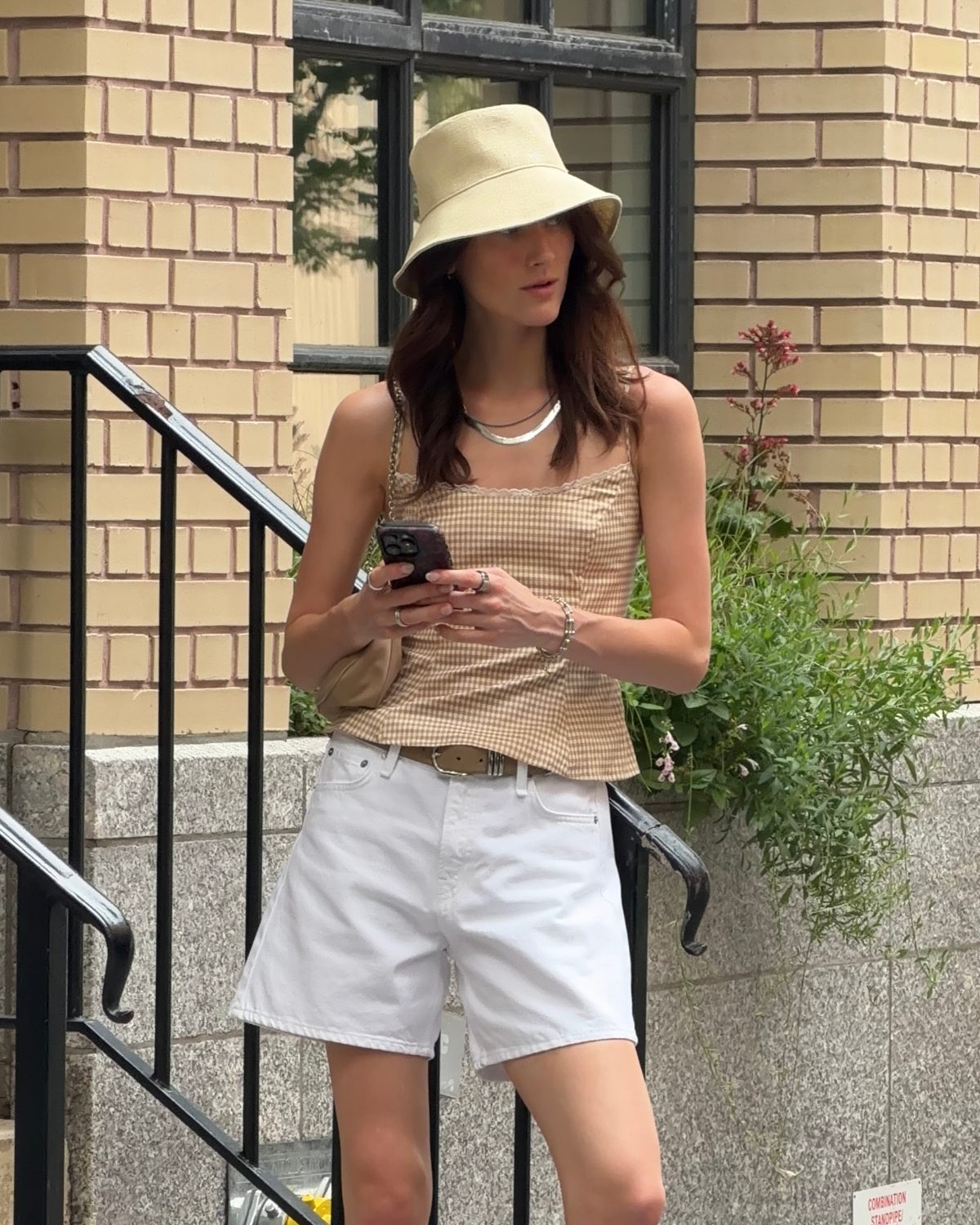 Beige gingham cami and white shorts with a bucket hat.