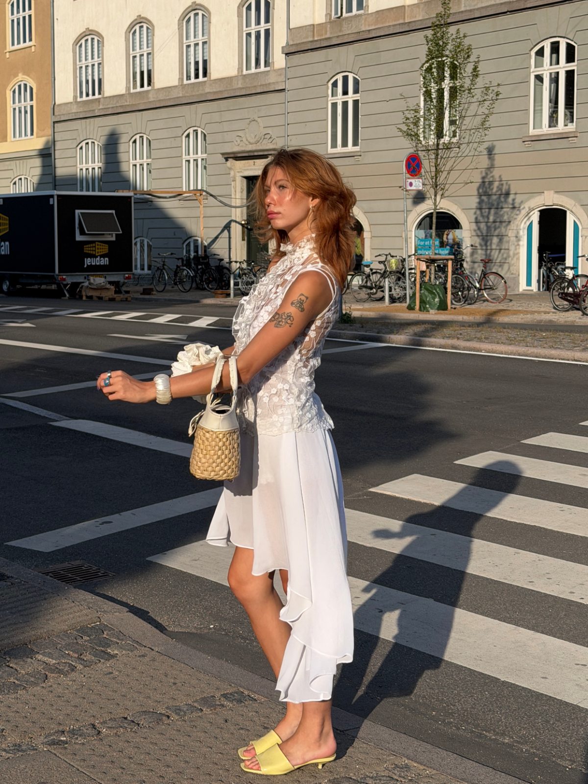 White ruffled lace top and asymmetrical skirt with yellow kitten heel mules.
