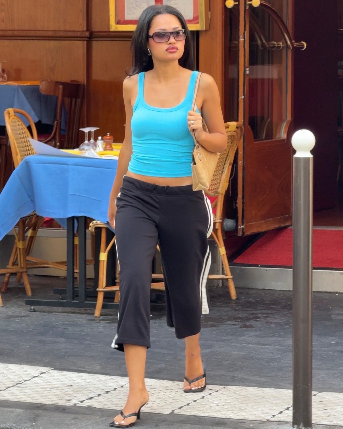 Light blue tank top, black capris with white stripes, and black heeled flip-flops.