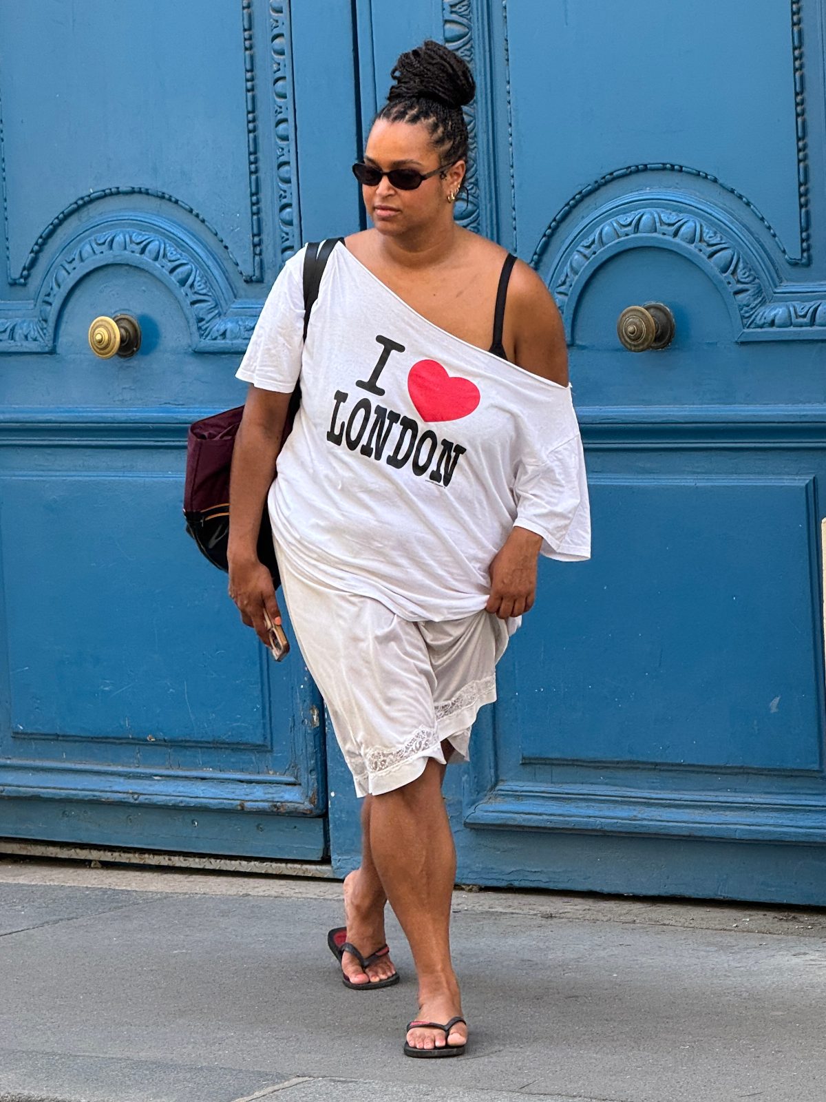 White "I ❤️ LONDON" off-shoulder tee, lace shorts, flip-flops, sunglasses, blue door.