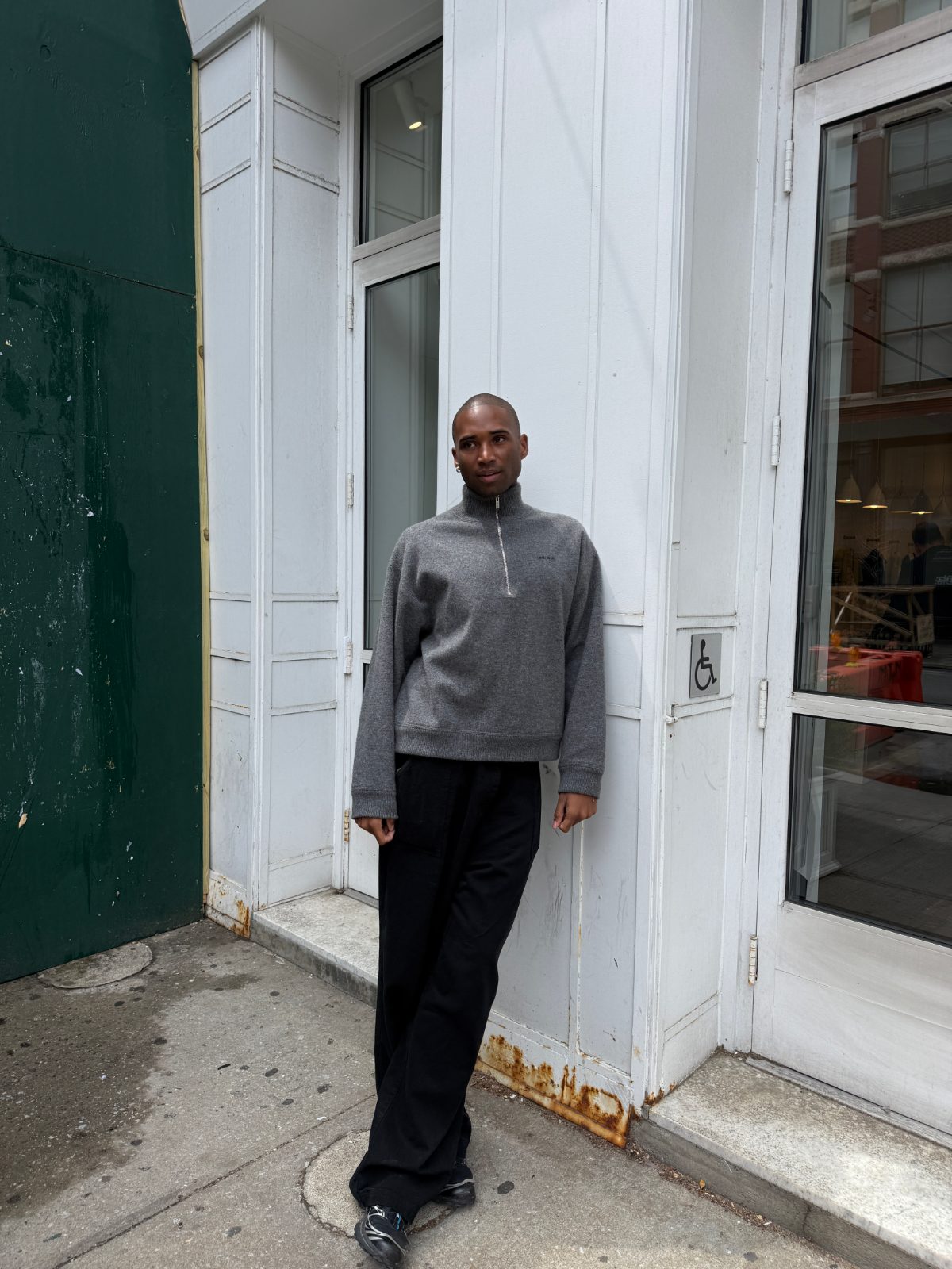 grey quarter-zip fleece pullover with wide-leg black trousers and dark footwear