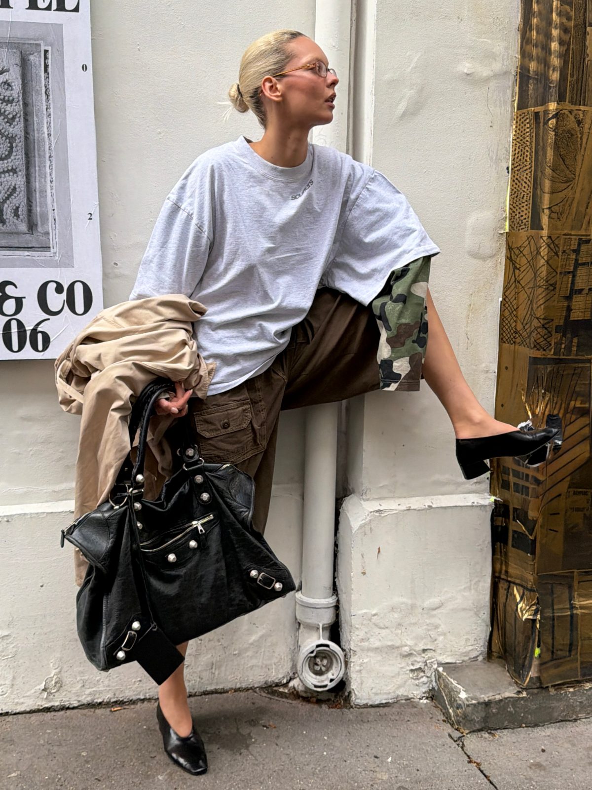 Gray oversized tee, brown cargo shorts, and black pointed-toe heels with a black handbag.