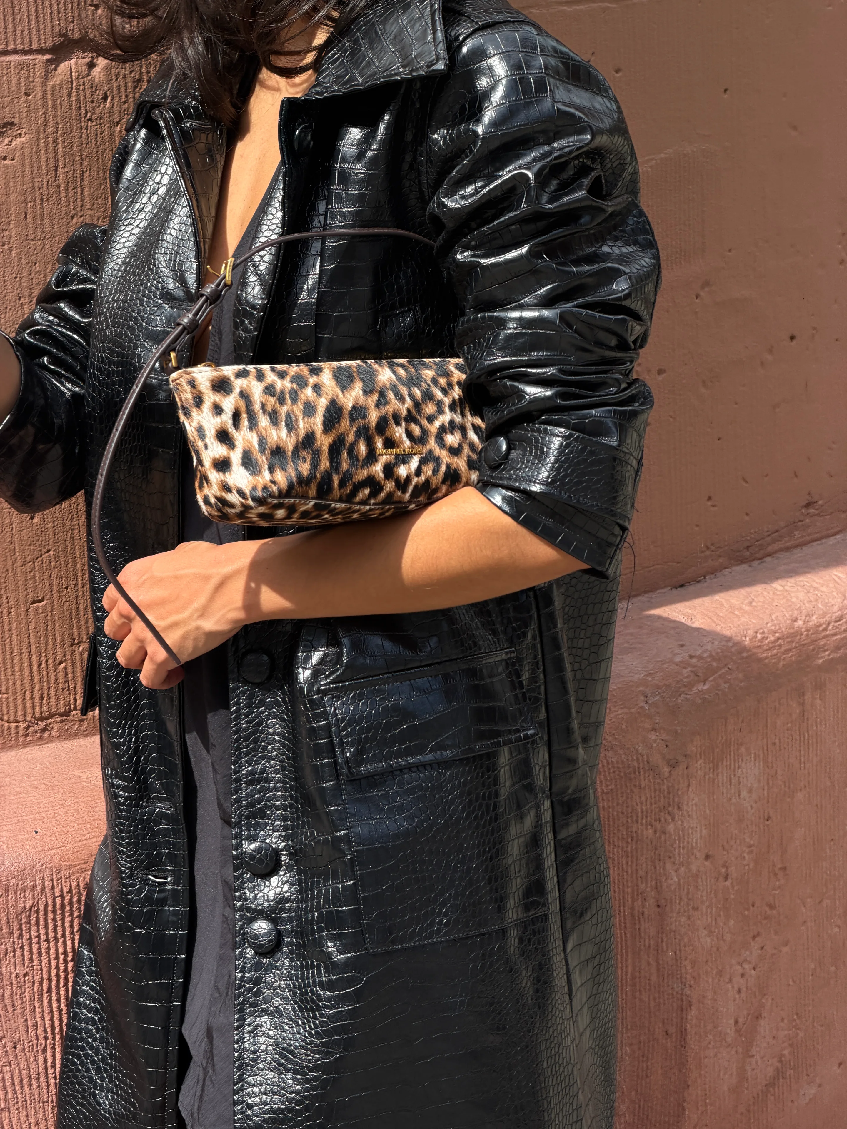 Black crocodile-embossed leather jacket with a leopard print handbag.