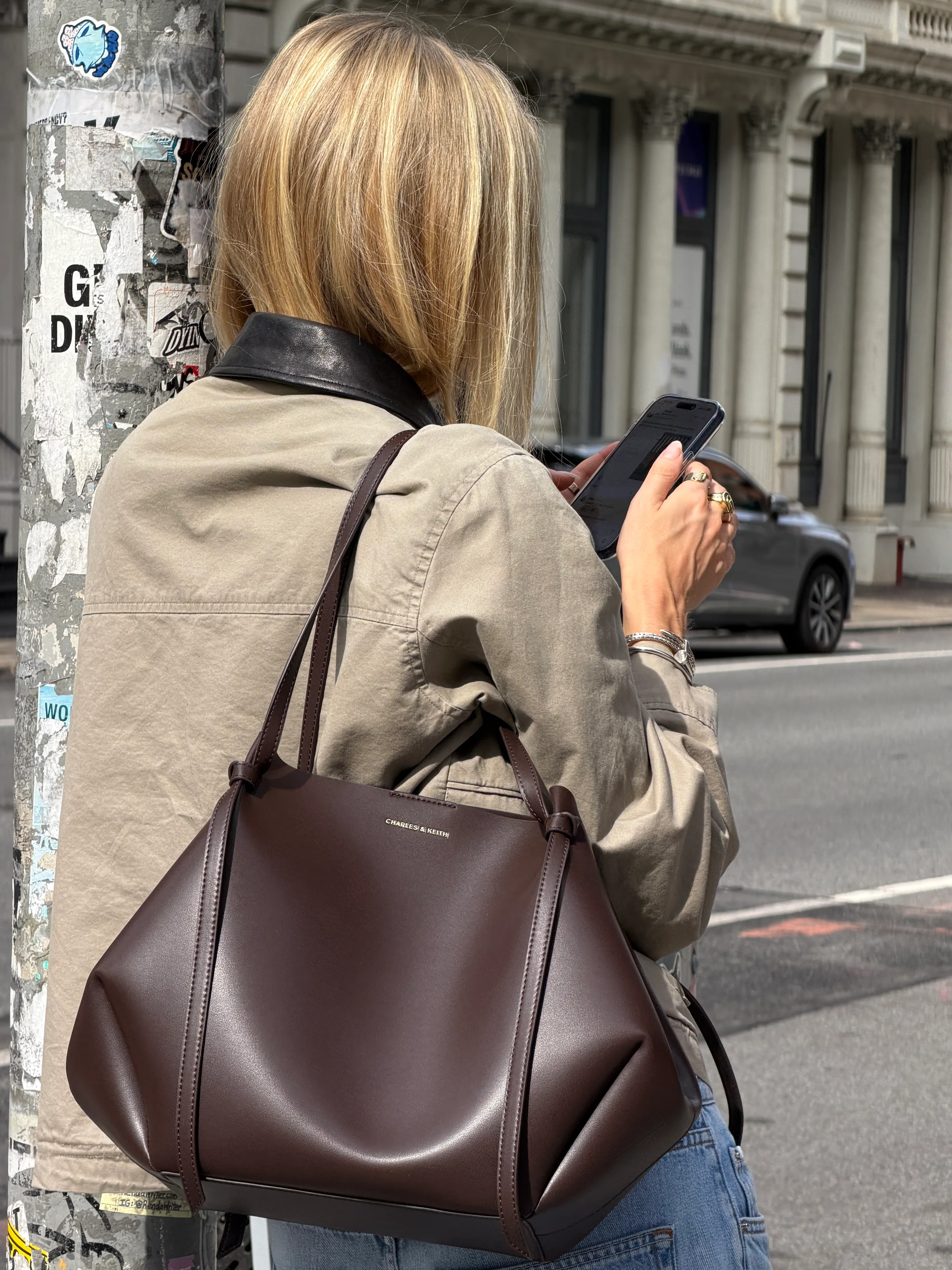 Khaki utility jacket with black collar, blue jeans, and brown CHARLES & KEITH tote bag.