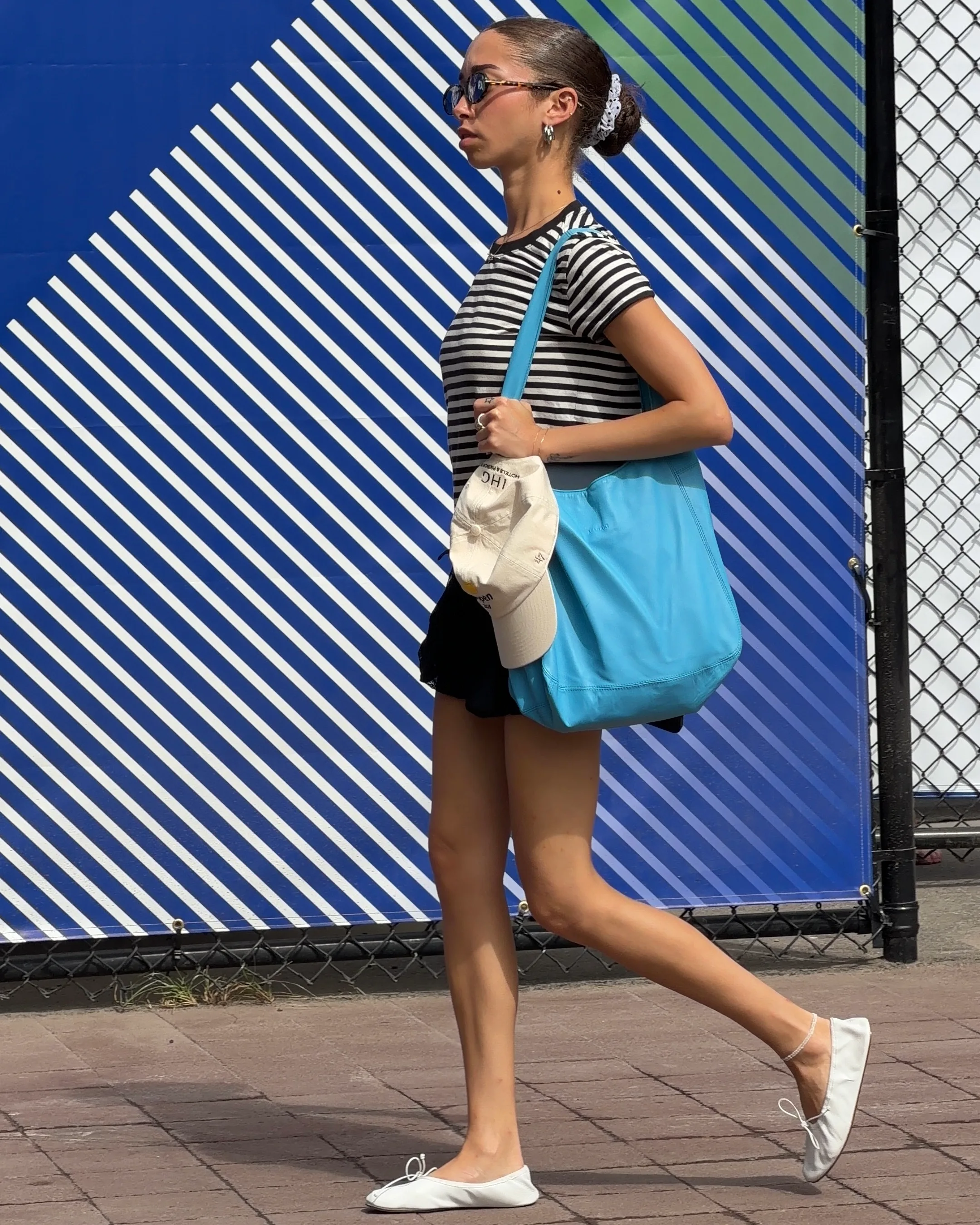 Black and white striped tee, black mini skirt, white ballet flats, and blue tote bag.