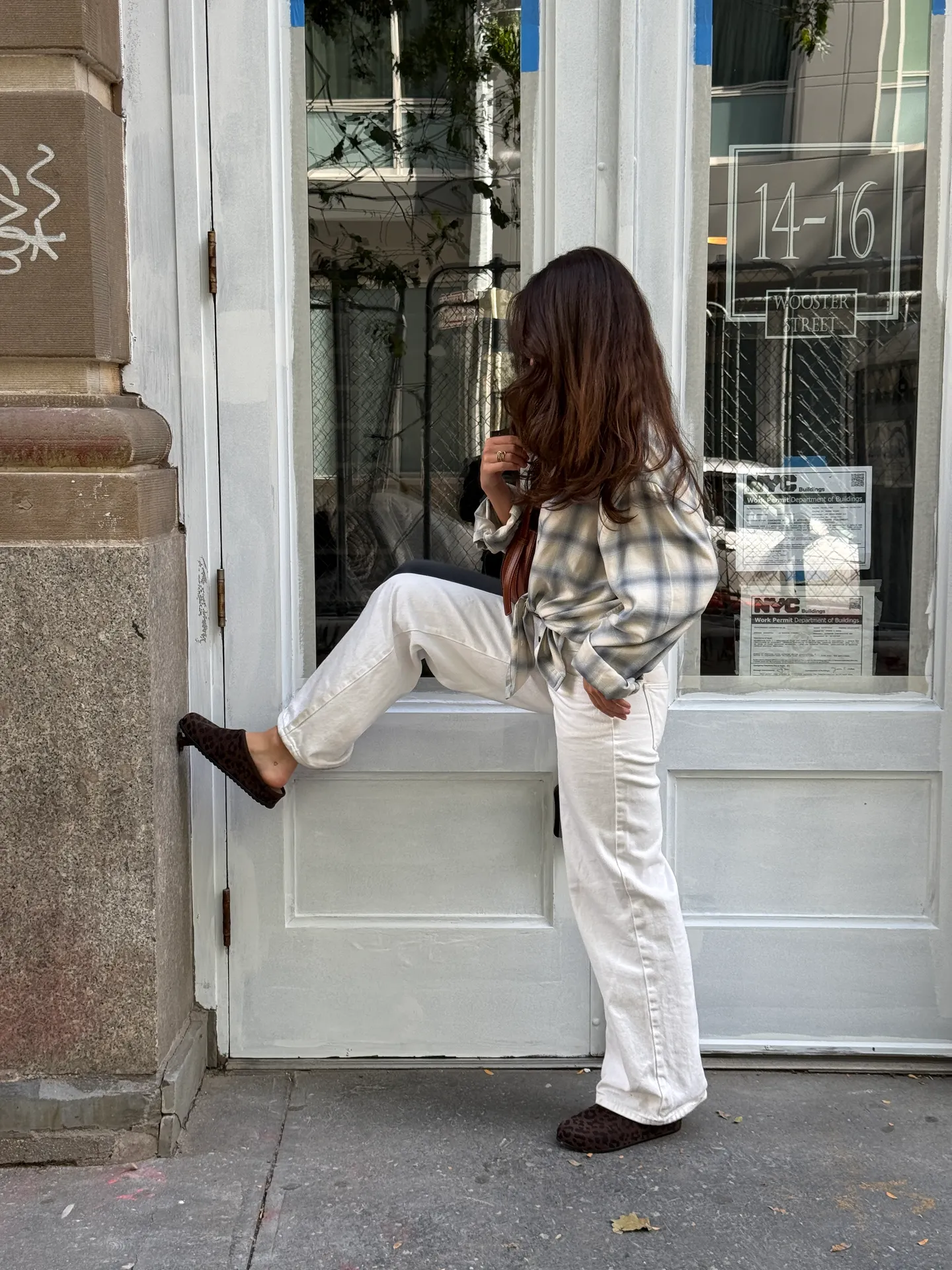 Blue and white plaid shirt, white wide-leg jeans, and dark leopard print slippers.
