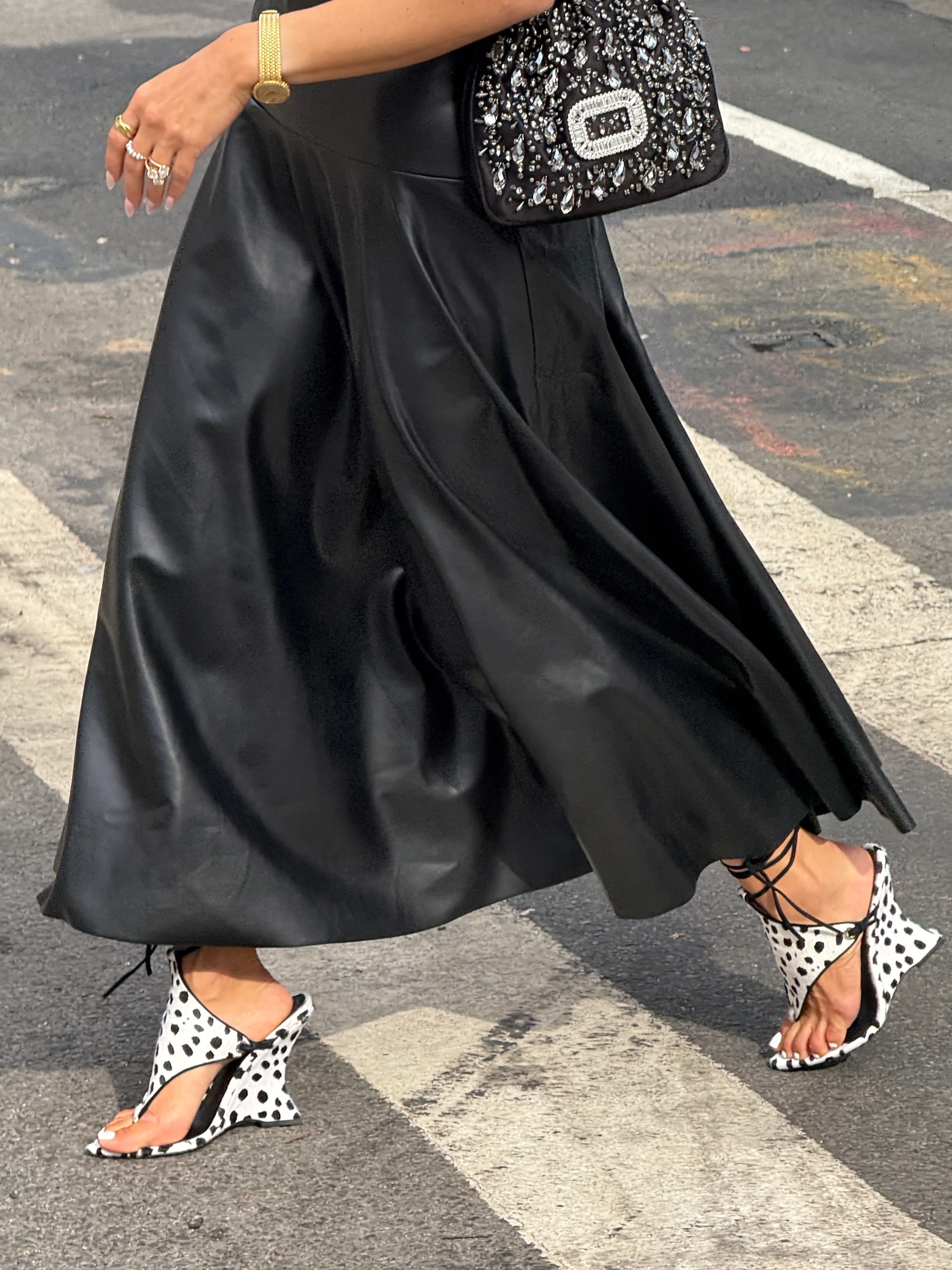 Black faux leather midi skirt with polka dot wedge sandals and a jeweled bag.