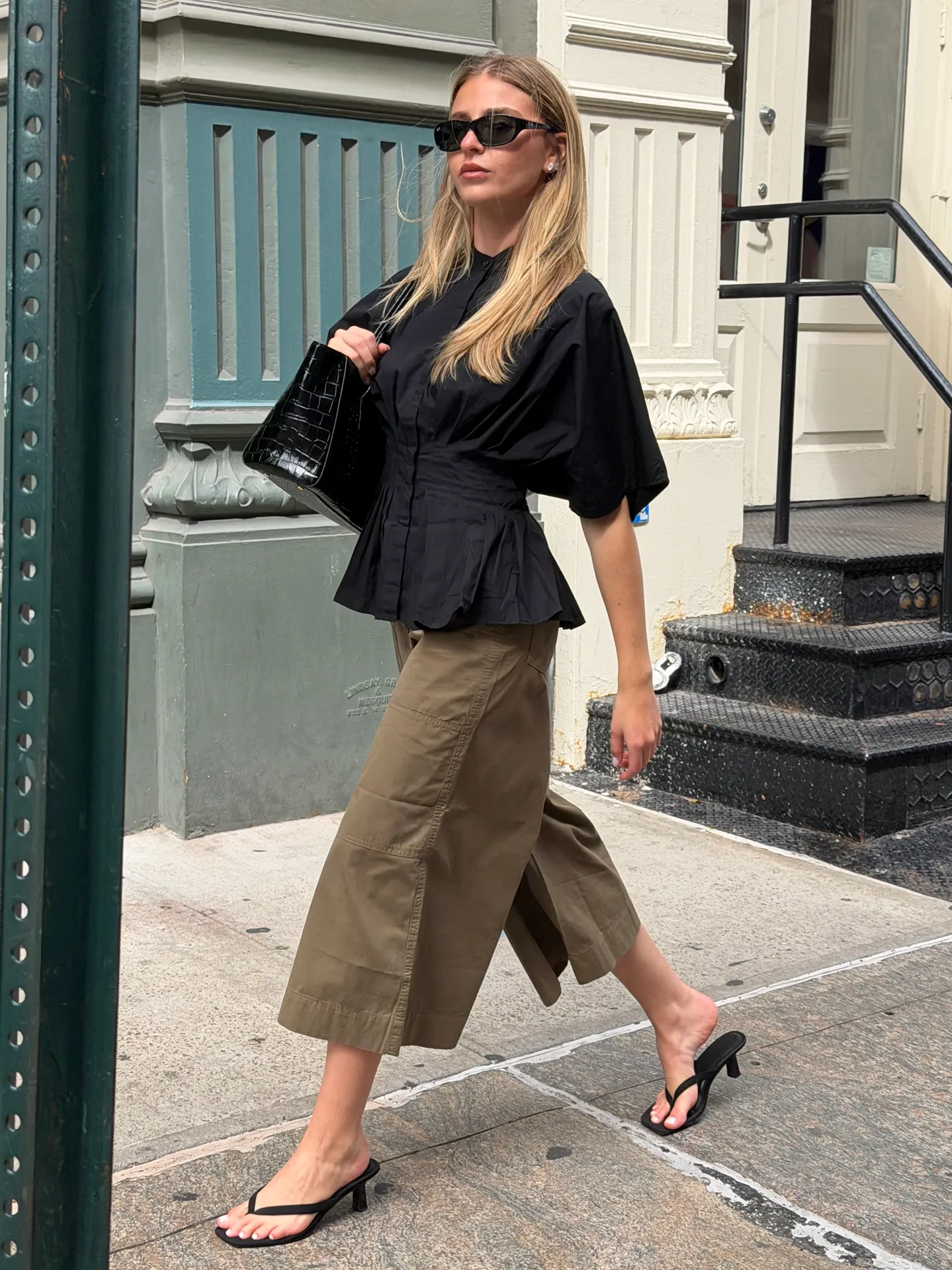 Black peplum blouse, olive green culottes, black kitten heel sandals, and sunglasses.