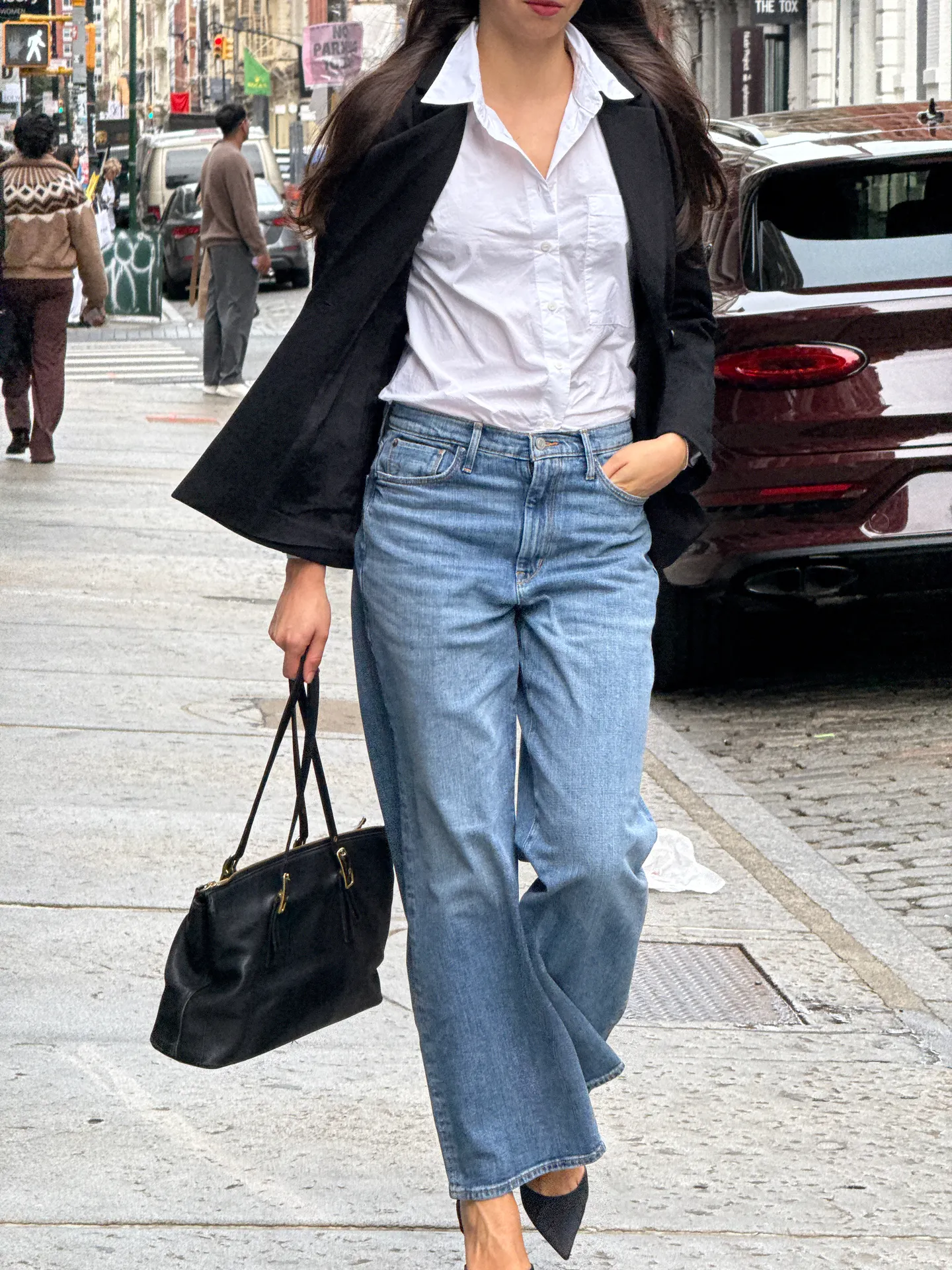 Black blazer, white shirt, light wash jeans, black tote bag, and pointed heels on street.