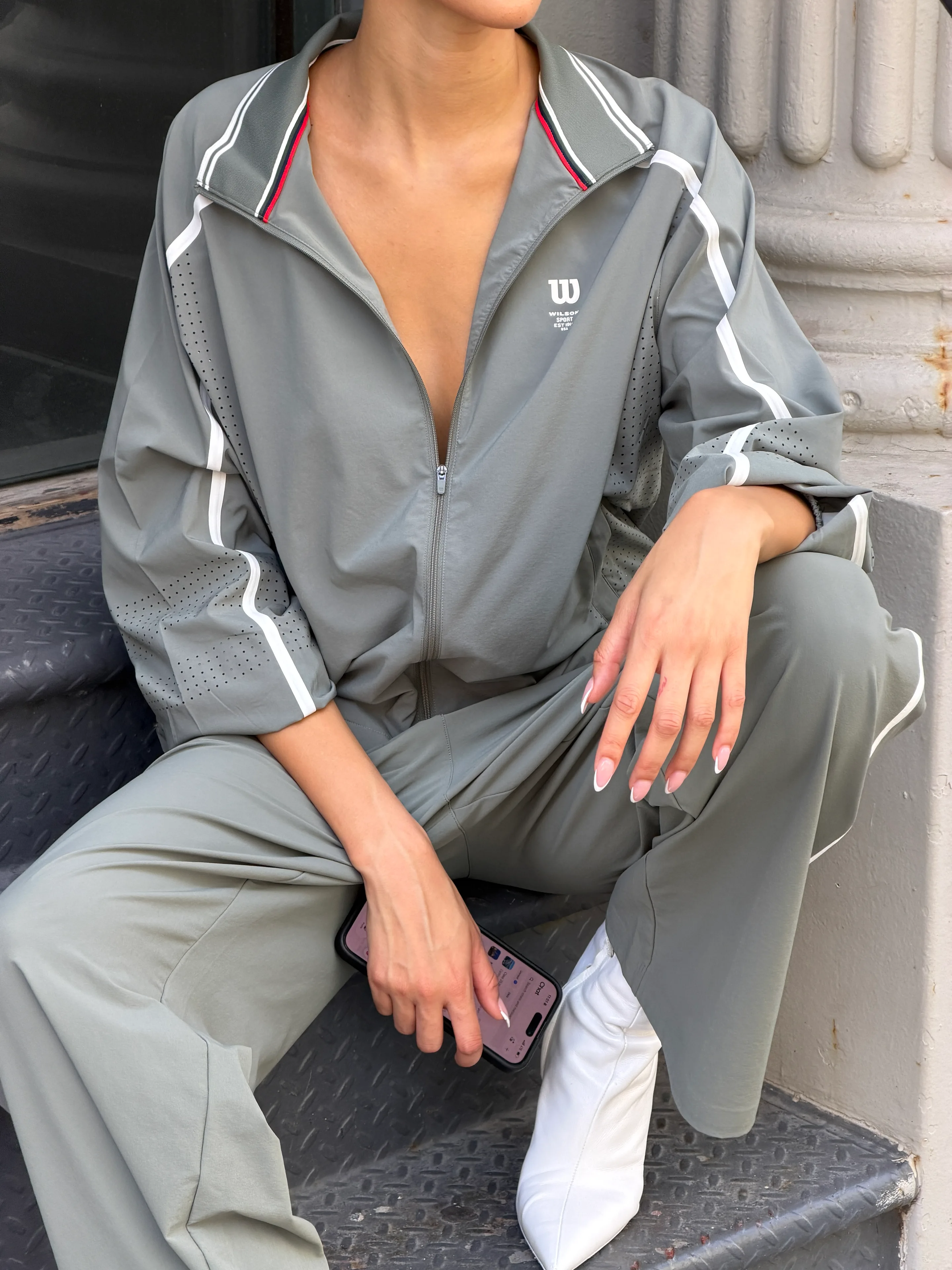 Gray Wilson tracksuit with white stripes, paired with white boots.