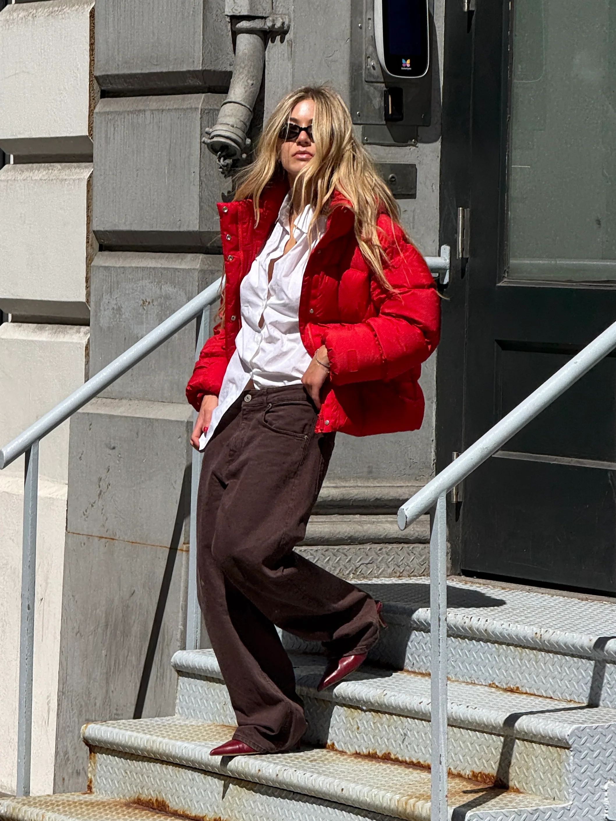 Red puffer jacket, white shirt, brown baggy jeans, red pointed-toe heels, and sunglasses.