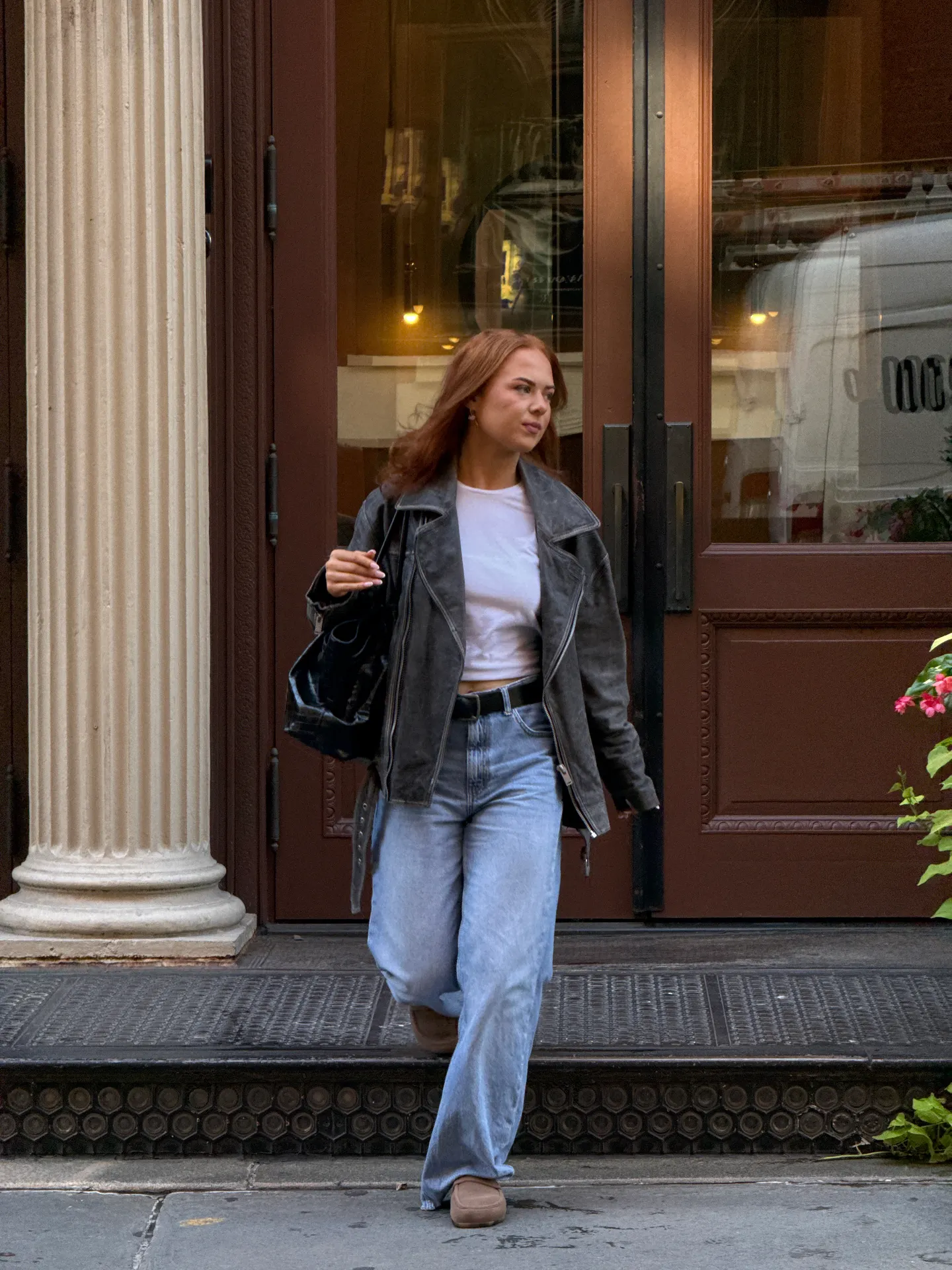 Charcoal leather biker jacket, white crop top, light wash baggy jeans, and moccasins.