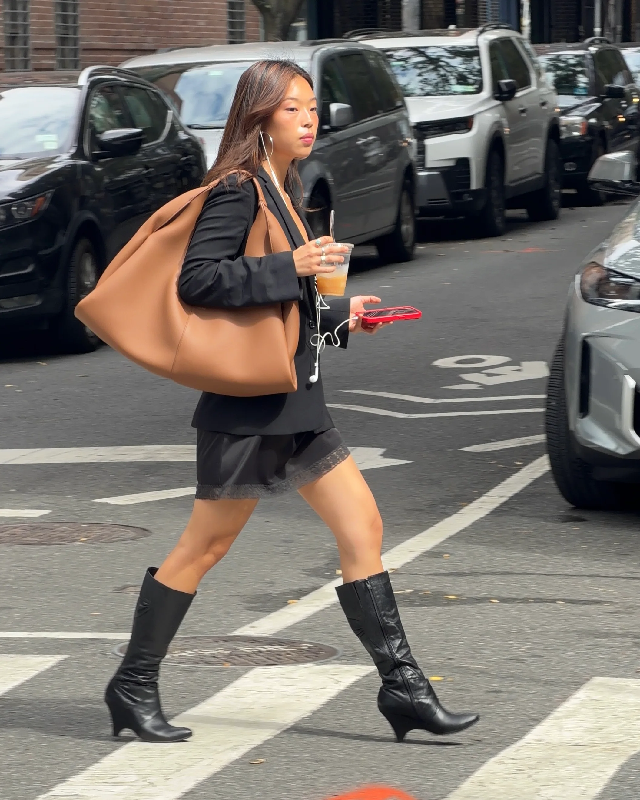 Black blazer, lace trim slip dress, and tall black boots with a large tan bag.