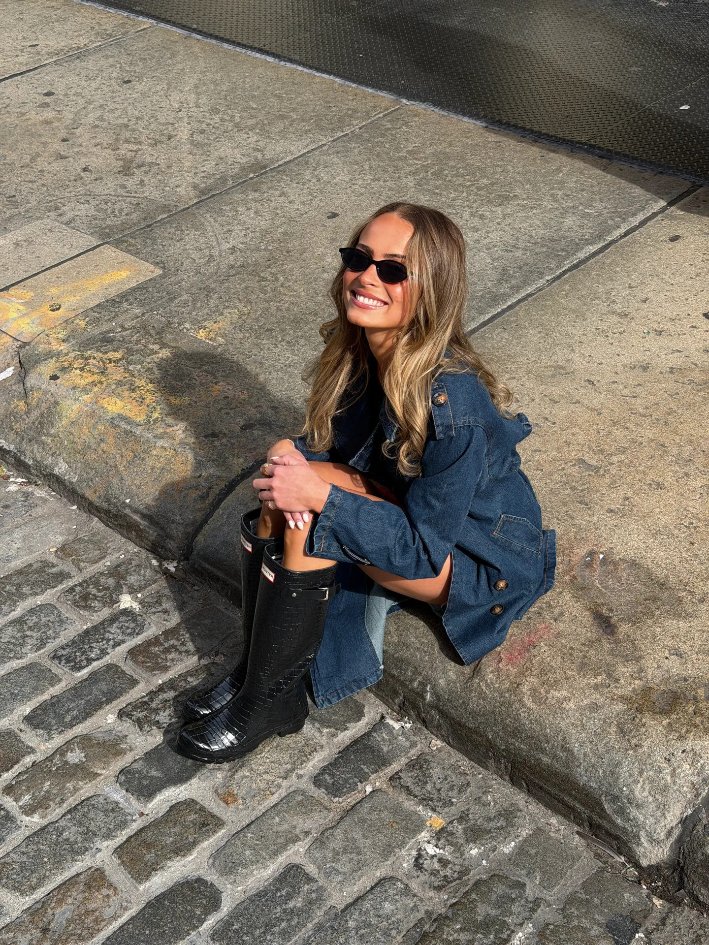 Denim button-up jacket with black crocodile-embossed Hunter rain boots.