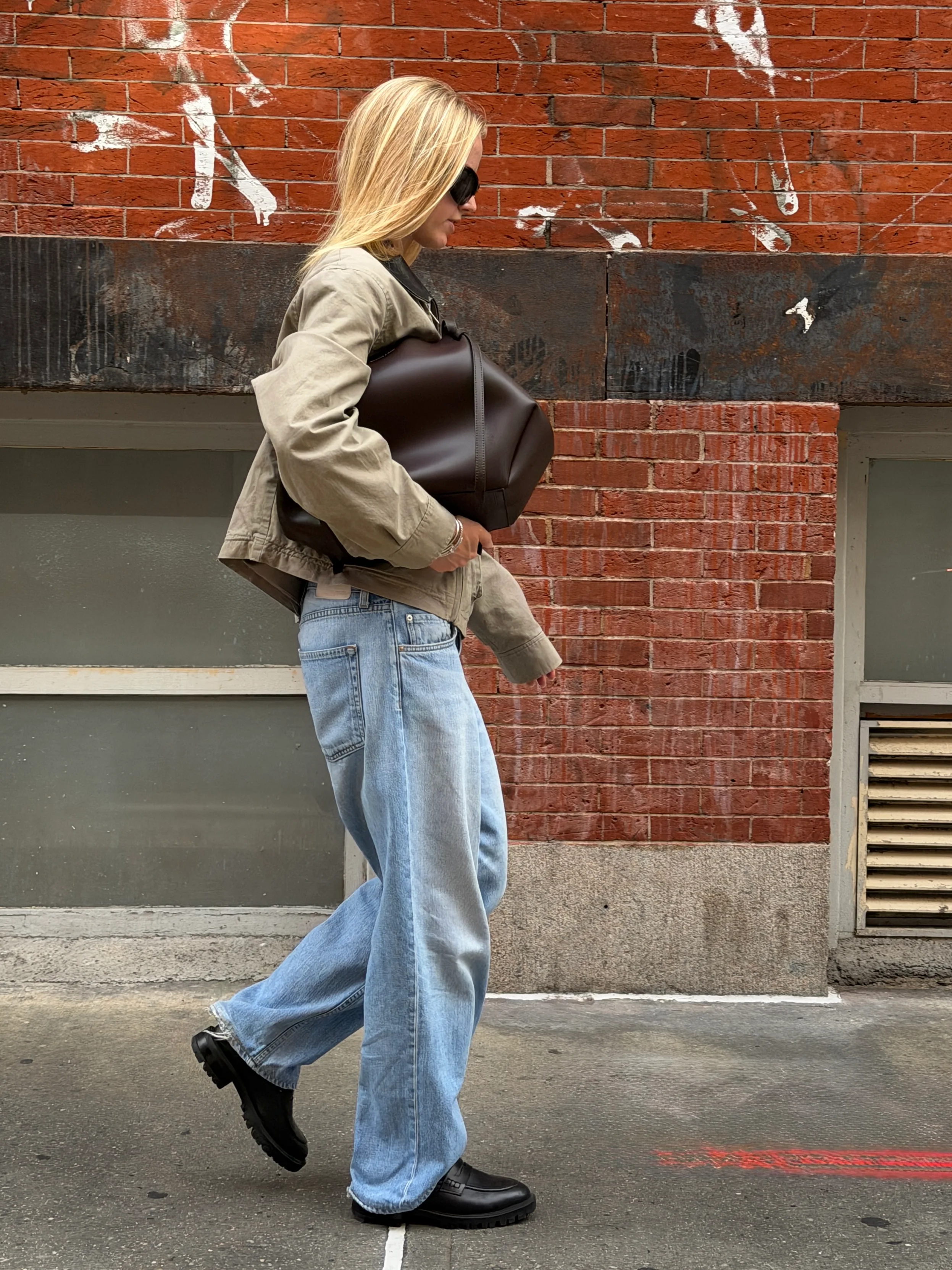 Khaki jacket, light-wash baggy jeans, and black lug-sole loafers.
