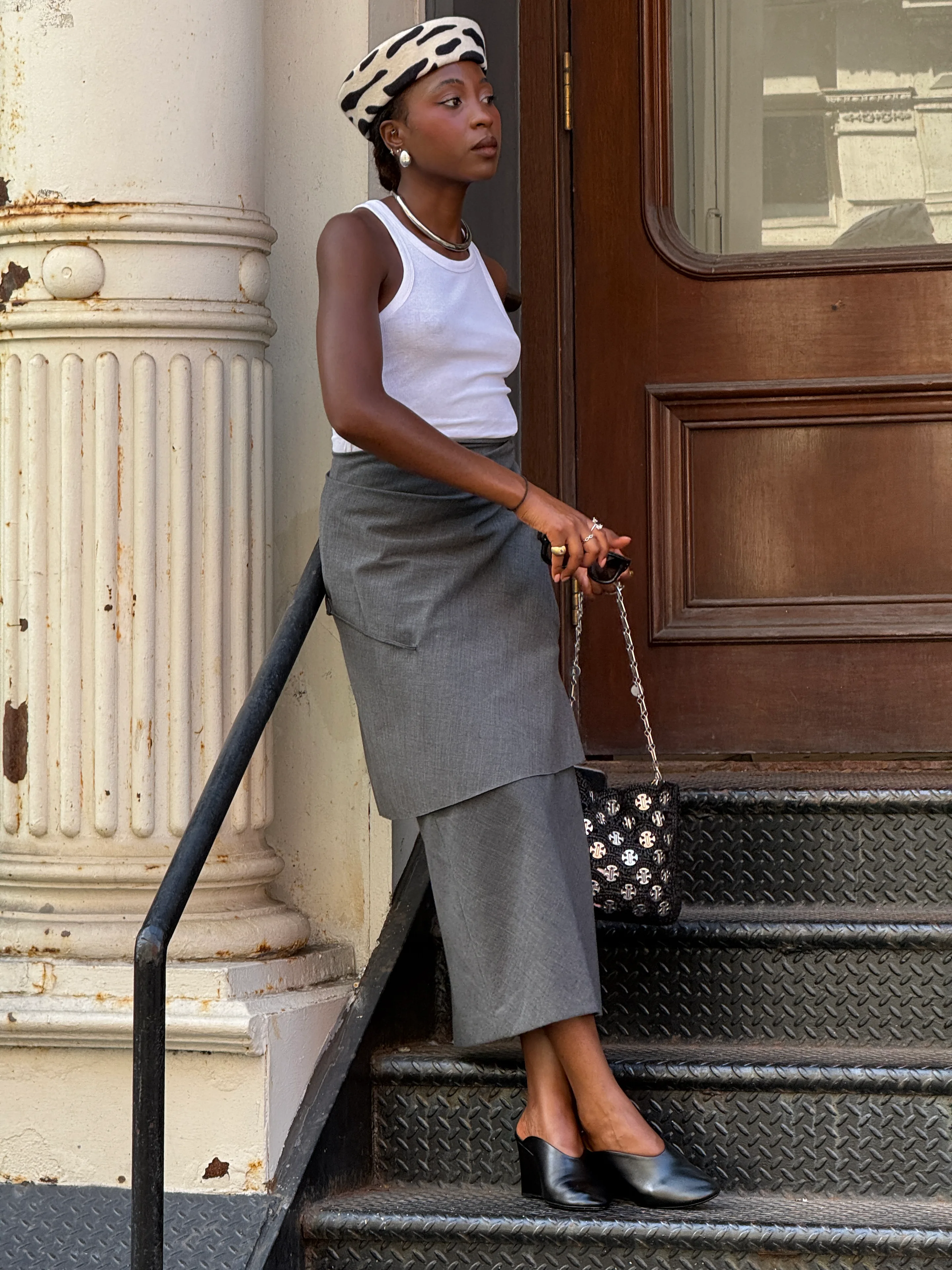 White tank top, gray asymmetric skirt, black mules, cow print beret.