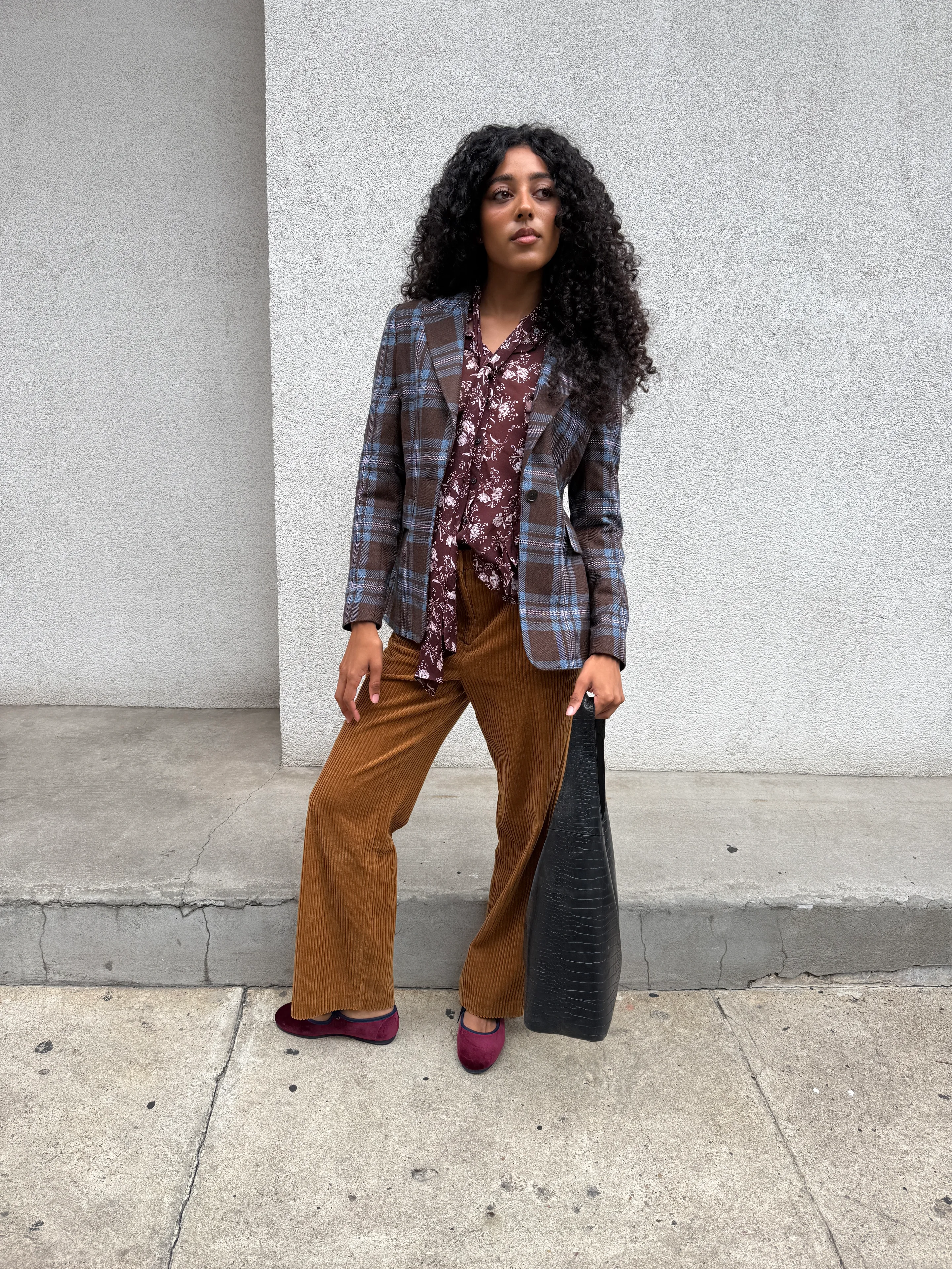 Plaid blazer, floral blouse, brown corduroy pants, and burgundy velvet flats with black bag.