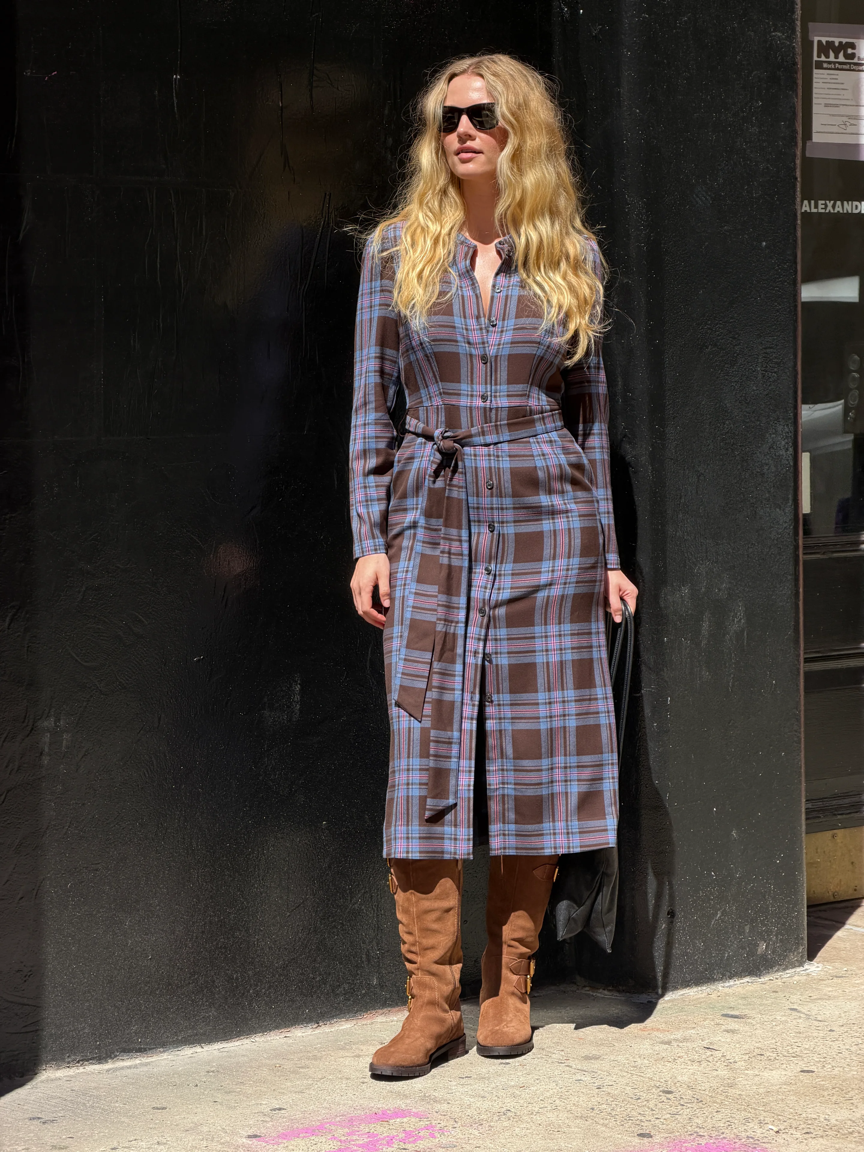 Brown plaid midi shirtdress with tie-waist, brown suede boots, and black sunglasses.