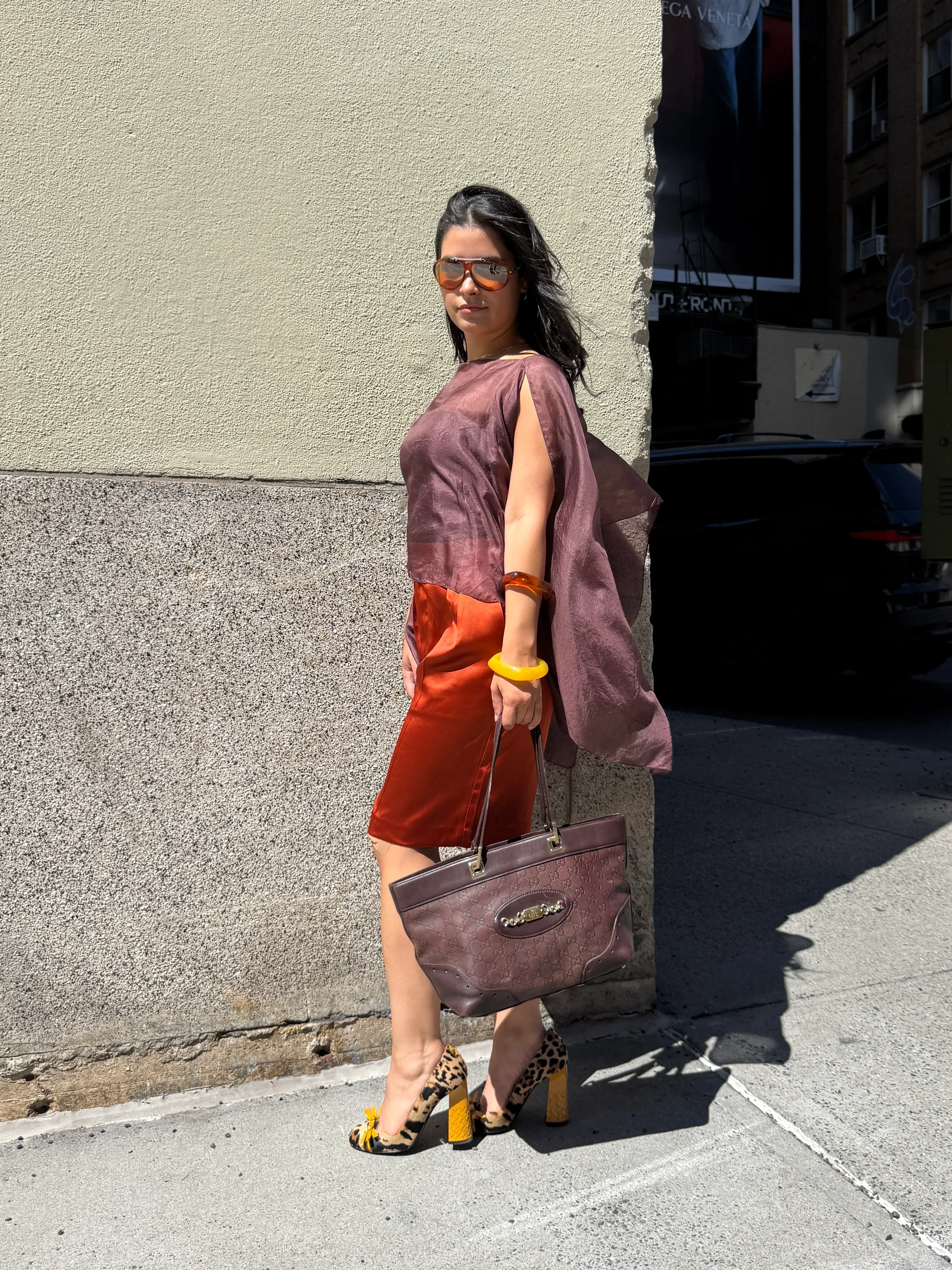 Brown sheer top with orange skirt, leopard print heels, sunglasses, and a brown Gucci bag.